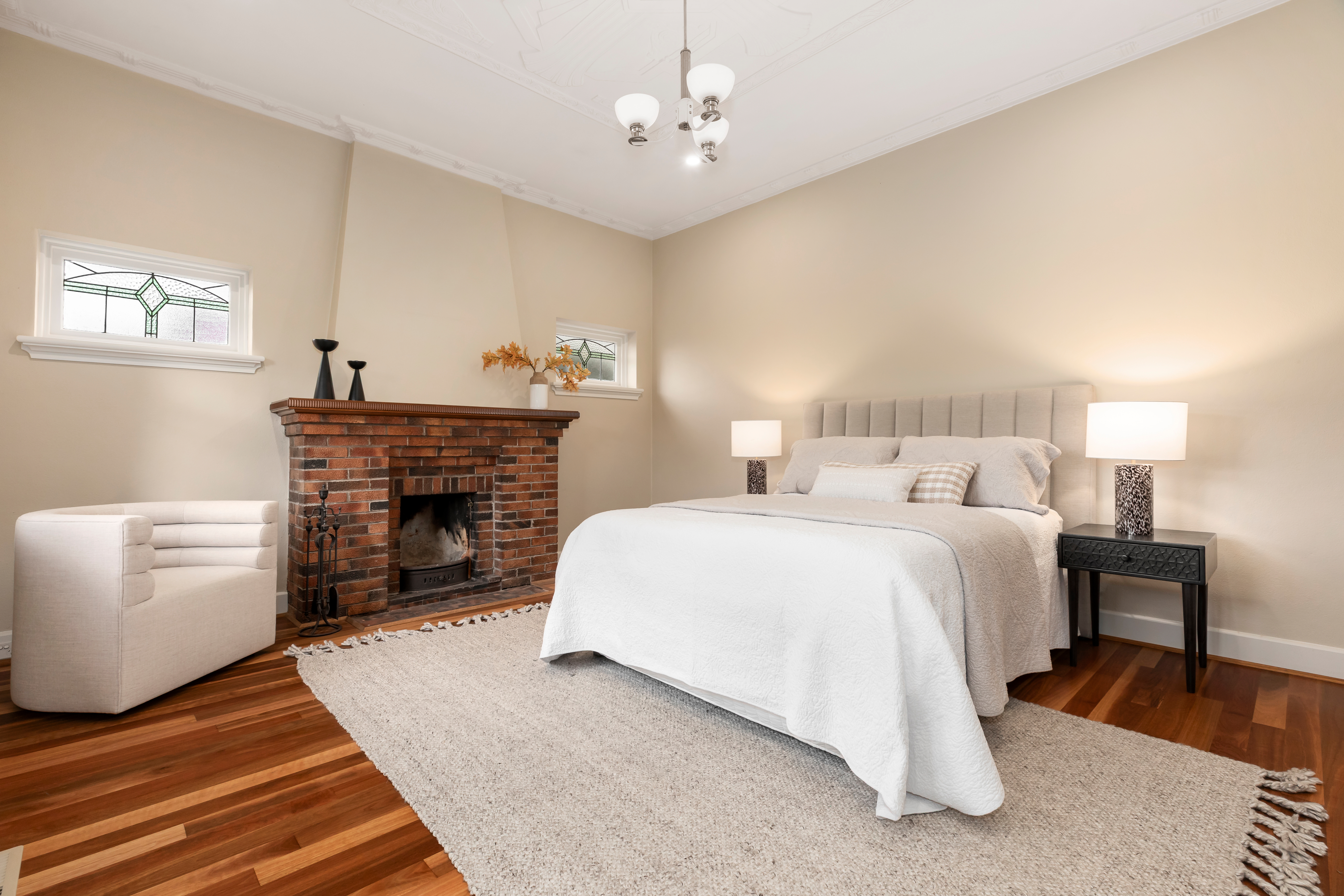 Styled master bedroom with upholstered bed, accent chair and layered textiles
